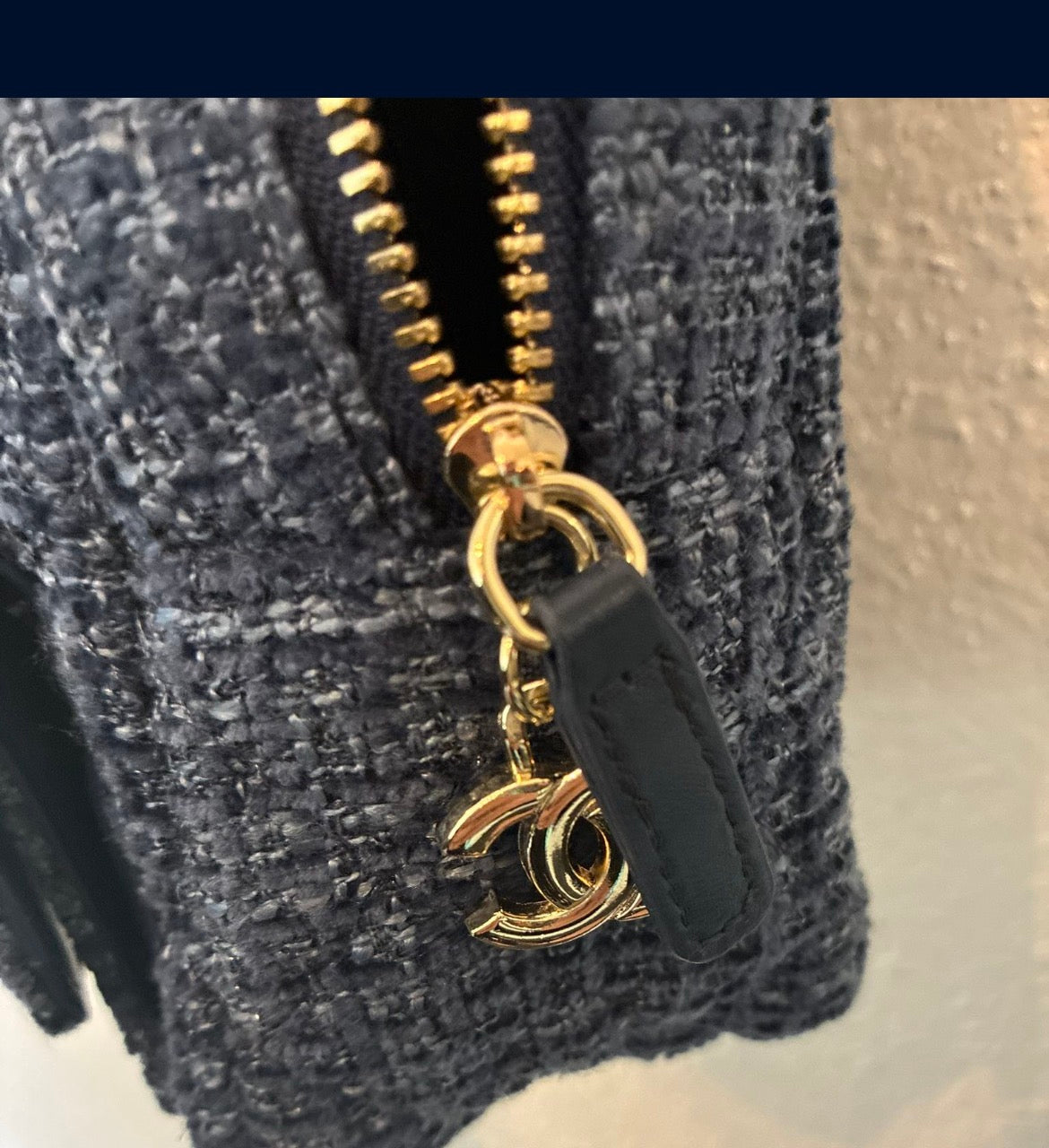 CHANEL backpack in navy tweed material with a quilted design.