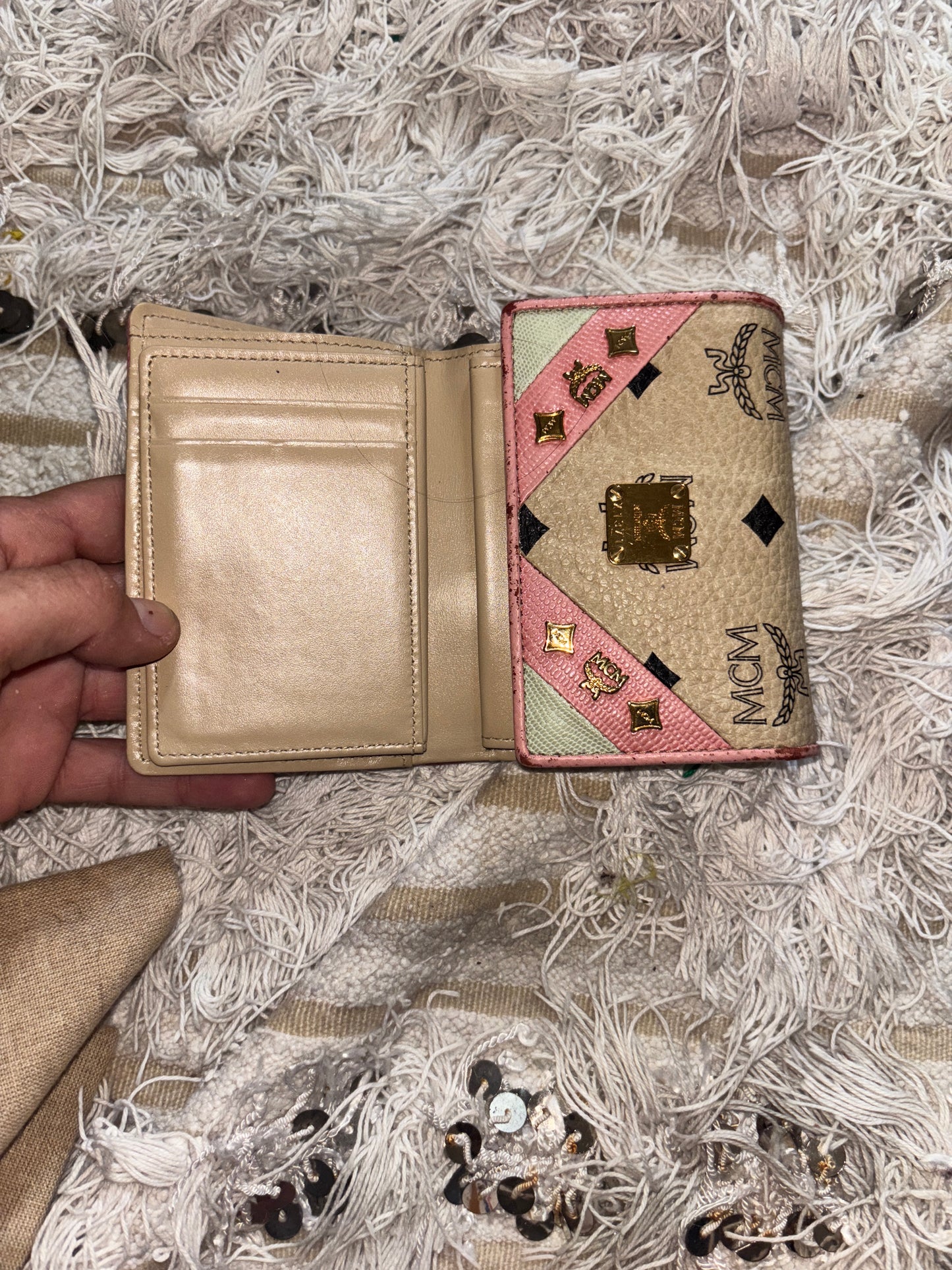 MCM wallet featuring a tri-color design with pink, beige, and green accents. It includes multiple card slots and a coin compartment, perfect for organizing essentials.
