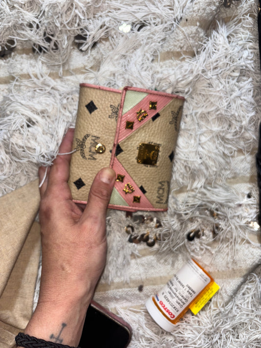 MCM wallet featuring a tri-color design with pink, beige, and green accents. It includes multiple card slots and a coin compartment, perfect for organizing essentials.